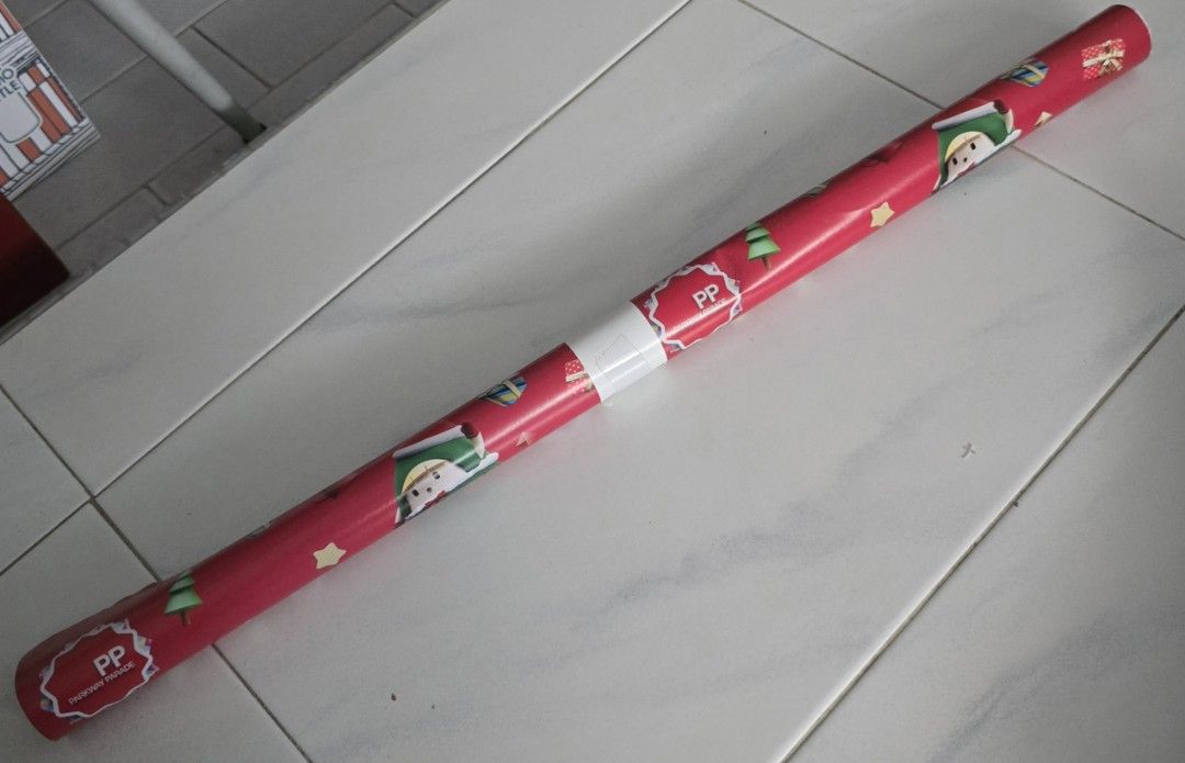 Gift Wrapper (Category: Craft Supplies & Tools) located in Singapore. Submitted by vickychan123 (Listing ID 1454859418, Image 1). Description: - Festive Christmas gift wrapper - Vibrant red background with cute elf, Christmas tree, and gift box patterns - Features 'PP Parkway Parade' branding - Ideal for wrapping gifts for christmas.