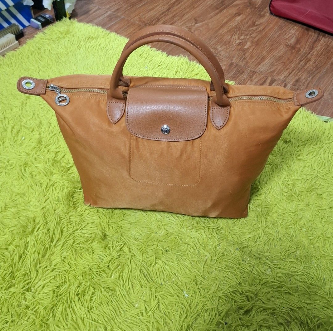 Original Medium Longchamp Cognac (Category: Luxury Bags & Wallets) located in Manila. Submitted by lexstrozzi (Listing ID 1454929885, Image 1). Description: Longchamp Le Pliage Original Top-Handle Bag (Medium) – Orange/Cognac Selling this classic Longchamp Le Pliage Original Medium Top-Handle bag in a beautiful, vibrant orange/cognac shade. Color: Orange / Cognac Leather Trim Material: Nylon body with leather flap and handles Features: Water-resi