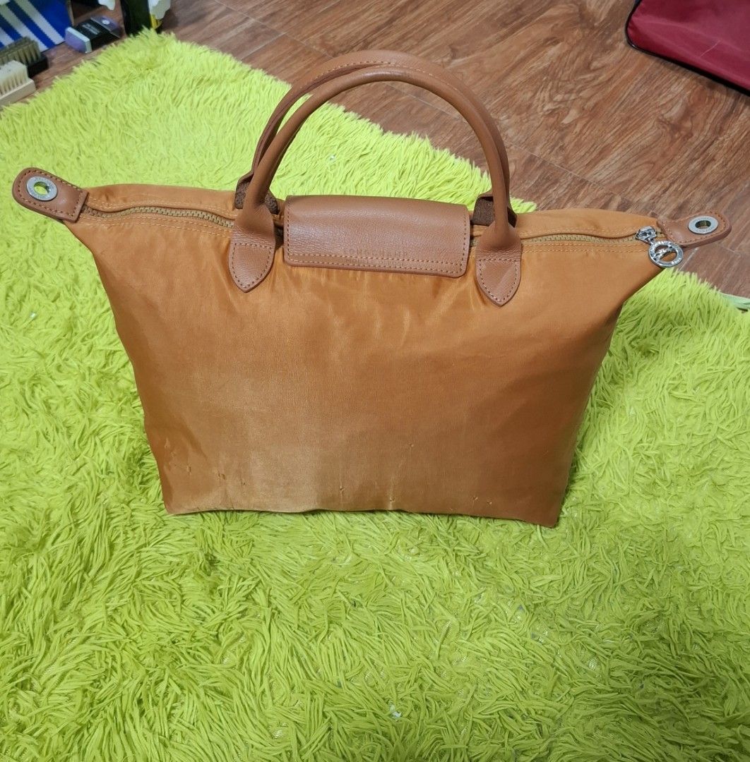 Original Medium Longchamp Cognac (Category: Luxury Bags & Wallets) located in Manila. Submitted by lexstrozzi (Listing ID 1454929885, Image 2). Description: Longchamp Le Pliage Original Top-Handle Bag (Medium) – Orange/Cognac Selling this classic Longchamp Le Pliage Original Medium Top-Handle bag in a beautiful, vibrant orange/cognac shade. Color: Orange / Cognac Leather Trim Material: Nylon body with leather flap and handles Features: Water-resi