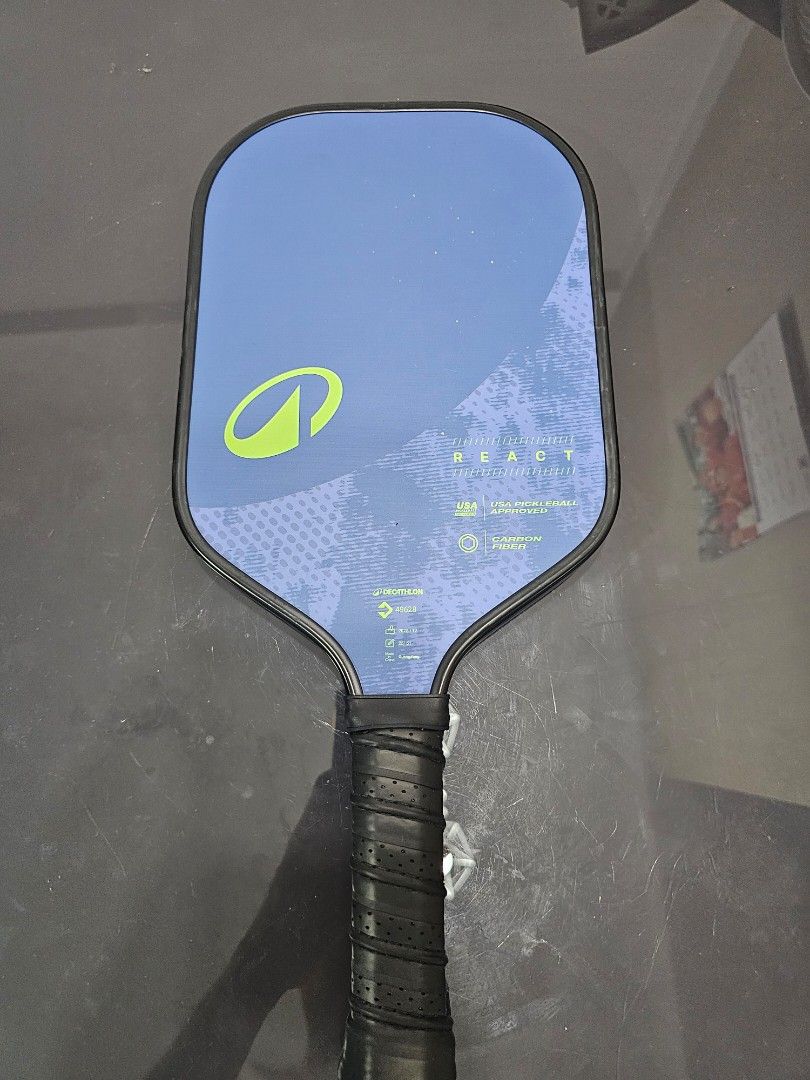 Pickleball Paddle React (Category: Racket & Ball Sports) located in Singapore. Submitted by kazuhikyo (Listing ID 1454882470, Image 2). Description: - Pickleball Paddle - Stylish blue and green design - Features vibration control technology - Enhanced grip with wrapped handle - Perfect for players aiming to elevate their game.