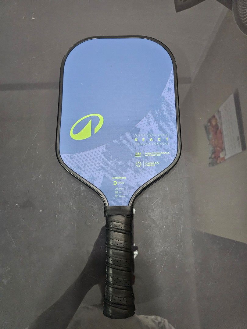 Pickleball Paddle React (Category: Racket & Ball Sports) located in Singapore. Submitted by kazuhikyo (Listing ID 1454882470, Image 1). Description: - Pickleball Paddle - Stylish blue and green design - Features vibration control technology - Enhanced grip with wrapped handle - Perfect for players aiming to elevate their game.
