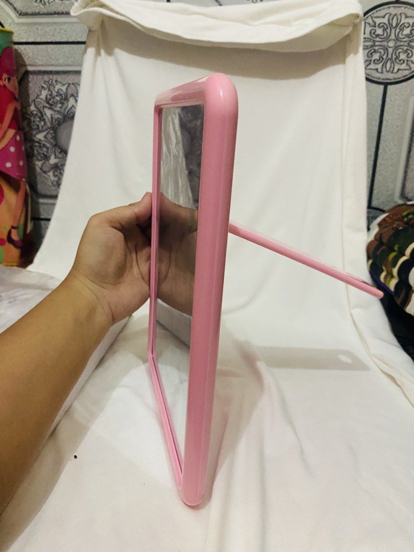 Pink Table Mirror (Category: Mirrors) located in Taguig. Submitted by chlia22 (Listing ID 1454882138, Image 3). Description: ✨ Pink frame ✨ Standing/free-standing design ✨ Can be tilted/adjusted for viewing ✨ Simple and cute aesthetic ✨ Price is NEGOTIABLE ✨ Great for makeup, hair, and OOTD checks Condition: Good pre-loved condition. May have minor signs of use/storage. Please check the photos for the actual condition..