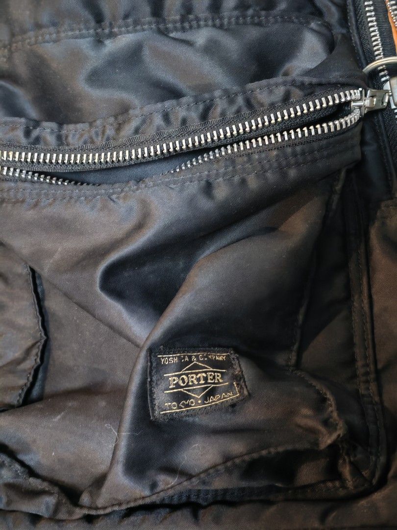 Porter Yoshida & Co. Japan Black Nylon Backpack (Category: Backpacks) located in Manila. Submitted by GentleGiant (Listing ID 1454884290, Image 2). Description: - Classic black nylon backpack from Porter Yoshida & Co. Japan. - Features multiple zippered compartments for organization. - Bright orange interior adds a pop of color. - Note: One strap shows wear and tear (refer to the last photo). - Still a functional and stylish bag for everyday use.