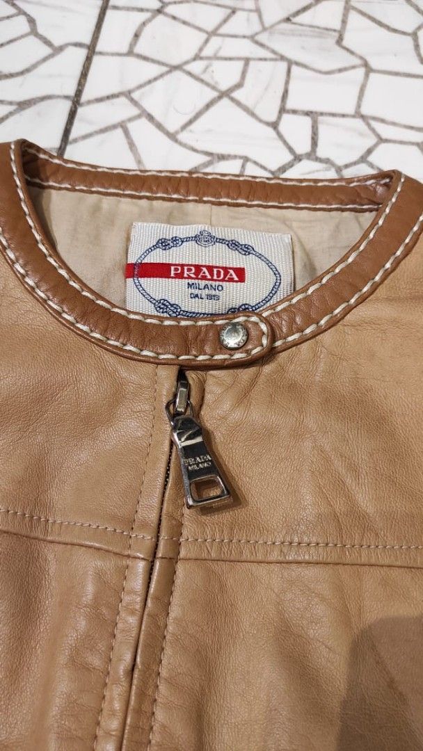 PRADA Brown Leather Short Sleeve Ruffle Jacket (Category: Luxury Apparel) located in Malolos. Submitted by highkeys (Listing ID 1454882097, Image 3). Description: - Prada brown leather jacket - Unique short sleeve design - Elegant ruffle hem - Stylish white contrast stitching throughout - Two functional front pockets - Secure zipper closure -Lenght 18" -width 17".