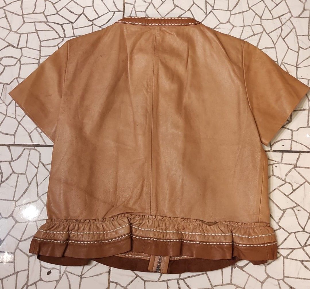 PRADA Brown Leather Short Sleeve Ruffle Jacket (Category: Luxury Apparel) located in Malolos. Submitted by highkeys (Listing ID 1454882097, Image 2). Description: - Prada brown leather jacket - Unique short sleeve design - Elegant ruffle hem - Stylish white contrast stitching throughout - Two functional front pockets - Secure zipper closure -Lenght 18" -width 17".