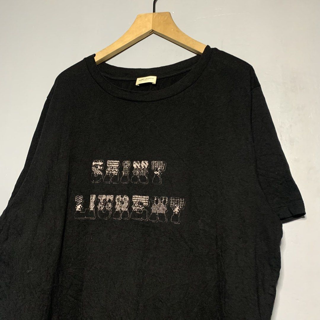 Saint Laurent Black Graphic T-Shirt (Category: Luxury Apparel) located in Manila. Submitted by emplysthrift. (Listing ID 1454882033, Image 2). Description: Width "23.5 Length "27 Likenew Condition Colorrate: 10/10 Flaws: maliit nahiwa Unli vouchers/vc for safe transactions 📲 Location: Laspinas City, Metro Manila, Brngy Talon Uno. 📍 DM IF INTERESTED📥 - Authentic Saint Laurent black t-shirt - Features a cool graphic print - Made from 100% comfor