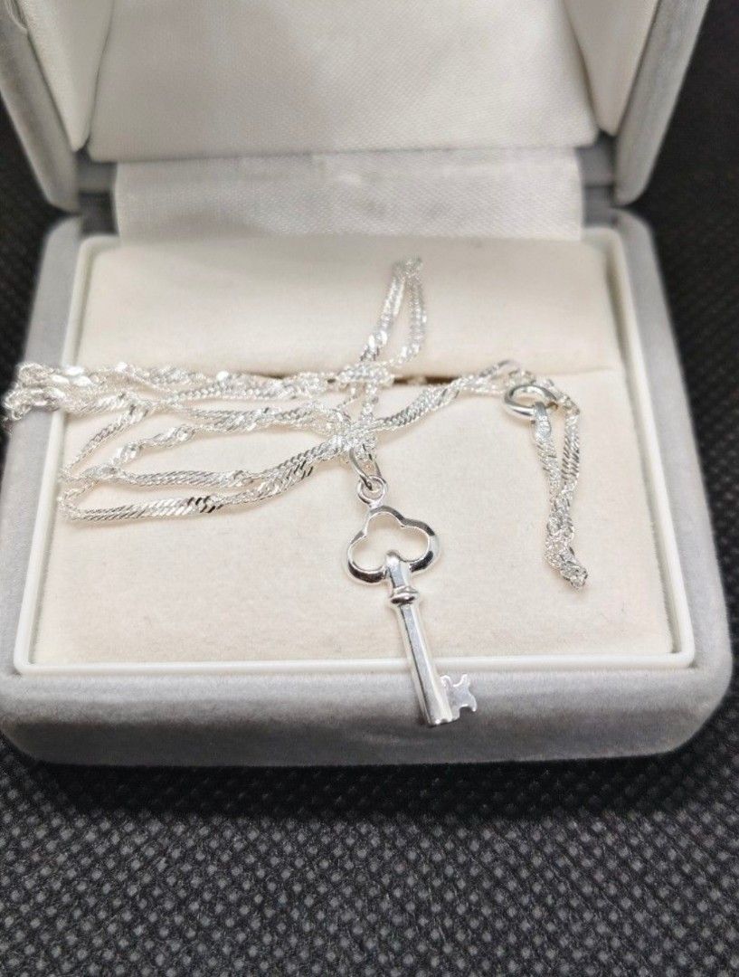 Silver key pendant necklace (Category: Necklaces) located in San Mateo. Submitted by joryee (Listing ID 1454786096, Image 2). Description: Two necklaces are available. One is orange, and the other is green. Both necklaces feature small, round beads. The orange necklace has gold-colored accents. The green necklace also has gold-colored accents. Both necklaces have a clasp closure..