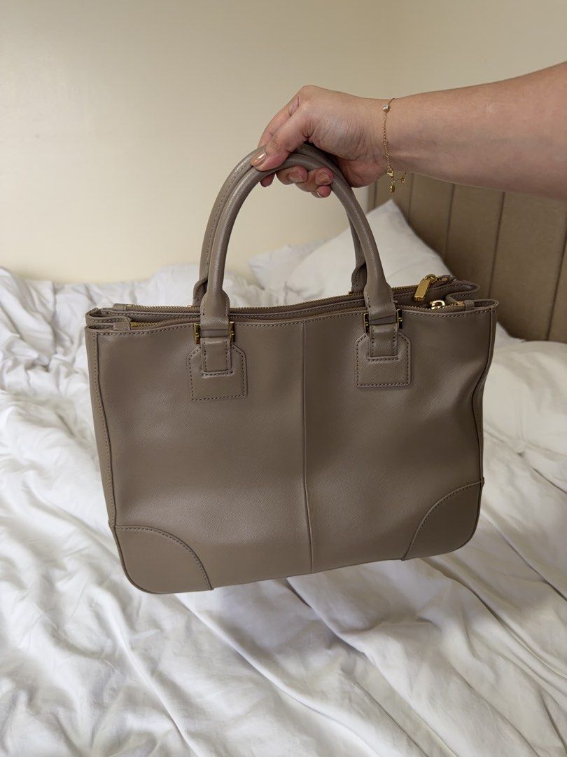 Tory Burch Tote Bag Taupe Leather (Category: Luxury Bags & Wallets) located in Cainta. Submitted by mama_memos (Listing ID 1454787941, Image 3). Description: - Brand: Tory Burch - Color: Taupe - Material: Leather - Closure: Zip - Handles: Top handles - Strap: Detachable shoulder strap - Hardware: Gold - Interior: Spacious - Best for: Everyday use.
