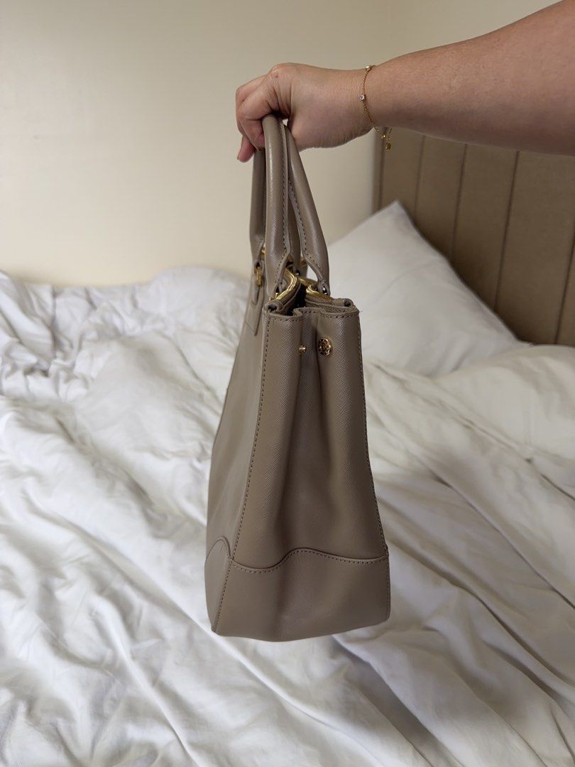 Tory Burch Tote Bag Taupe Leather (Category: Luxury Bags & Wallets) located in Cainta. Submitted by mama_memos (Listing ID 1454787941, Image 2). Description: - Brand: Tory Burch - Color: Taupe - Material: Leather - Closure: Zip - Handles: Top handles - Strap: Detachable shoulder strap - Hardware: Gold - Interior: Spacious - Best for: Everyday use.