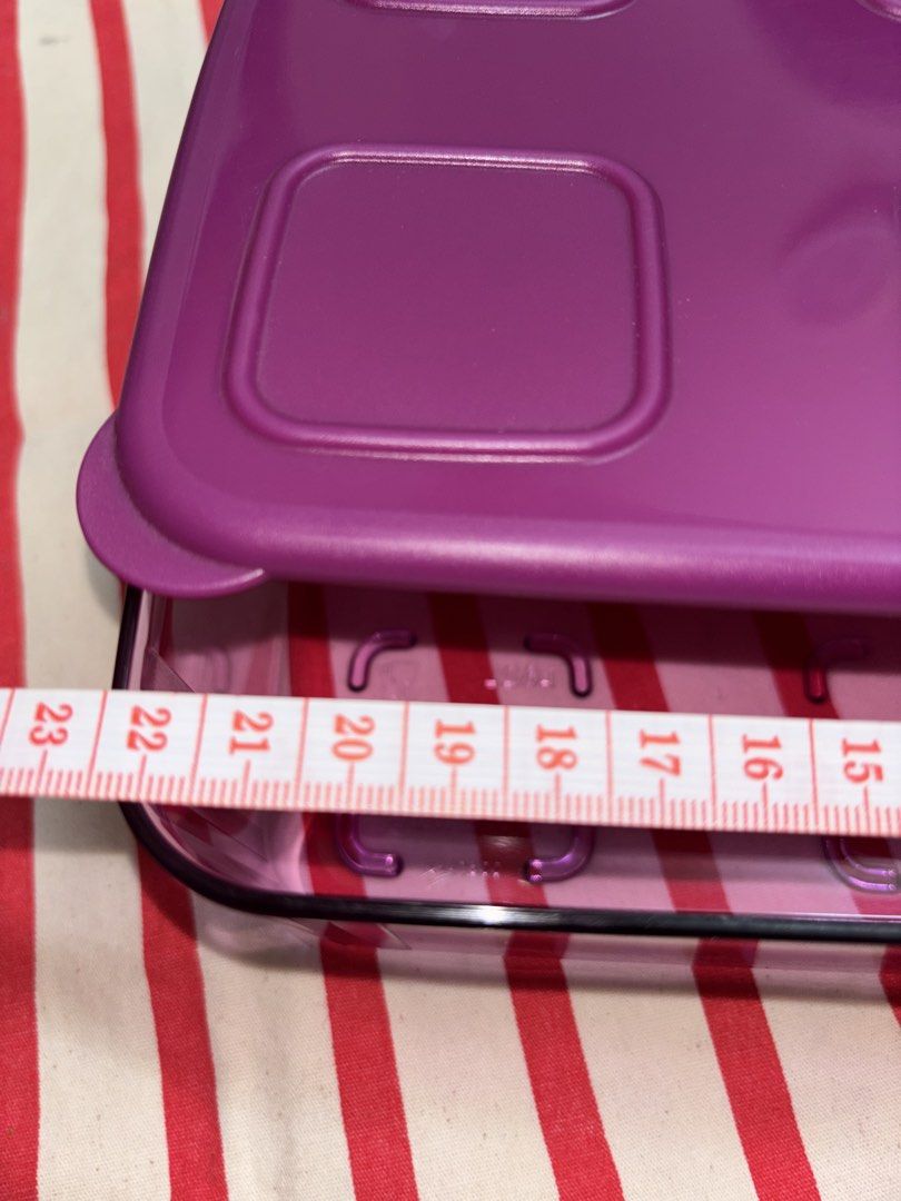 Tupperware Container (Category: Packaged & Instant Food) located in Rawang. Submitted by Mallll (Listing ID 1454819210, Image 3). Description: - Brand: Tupperware - Color: Purple - Design: Features a lid with six square indentations - Condition: Good, pre-loved (10/10) - Material: Tupperware - Use: Ideal for food storage and organization - Original from Tupperware or moneyback guarantee PM FOR SERIOUS BUYER ONLY.