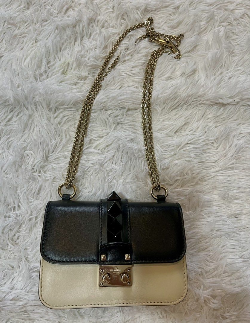 Valentino Rockstud Shoulder Bag Black Cream (Category: Luxury Bags & Wallets) located in Manila. Submitted by fasttree-3c0a1d (Listing ID 1454900872, Image 1). Description: - Authentic Valentino shoulder bag - Color: Black and Cream - Signature Rockstud detailing - Gold chain strap - Secure turn-lock closure - Small size, perfect for essentials.