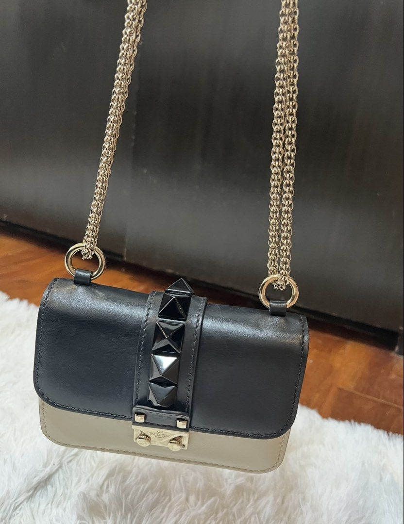 Valentino Rockstud Shoulder Bag Black Cream (Category: Luxury Bags & Wallets) located in Manila. Submitted by fasttree-3c0a1d (Listing ID 1454900872, Image 2). Description: - Authentic Valentino shoulder bag - Color: Black and Cream - Signature Rockstud detailing - Gold chain strap - Secure turn-lock closure - Small size, perfect for essentials.