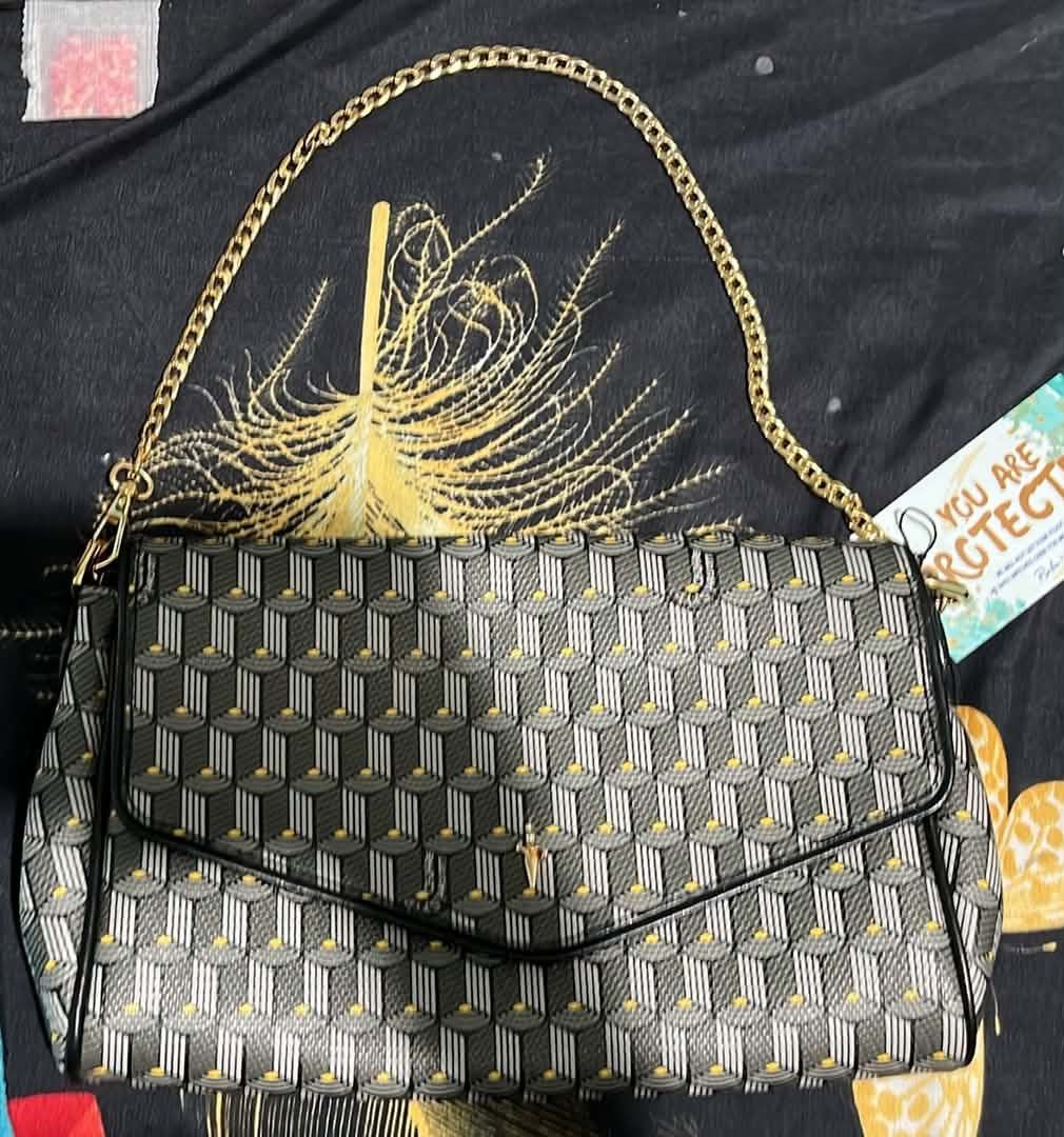 4US CESARE PACIOTTI (Category: Luxury Bags & Wallets) located in Cagayan de Oro. Submitted by apbeja (Listing ID 1455138605, Image 1). Description: Classic Longchamp shoulder bag. Features the signature geometric pattern in grey, black, and yellow. Gold chain strap. Envelope flap closure. Great for day or night. Clean interior. Comes with dust bag..