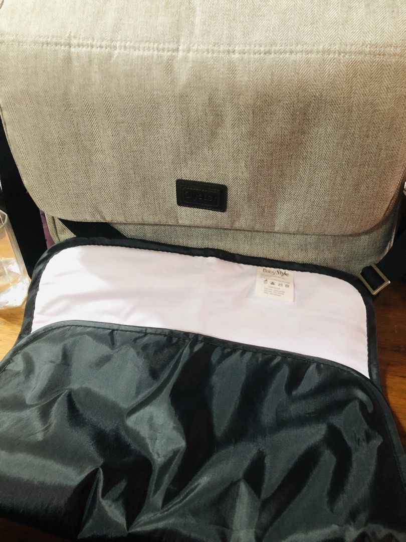 Baby Style Diaper Bag Messenger Bag (Category: Diaper Bags & Wetbags) located in Manila. Submitted by noemiaspa1702 (Listing ID 1455102753, Image 2). Description: - Grey herringbone diaper bag - Flap closure with black strap - Includes a changing mat - Features a shoulder strap for easy carrying - Plenty of space inside - Ideal for parents on the go.
