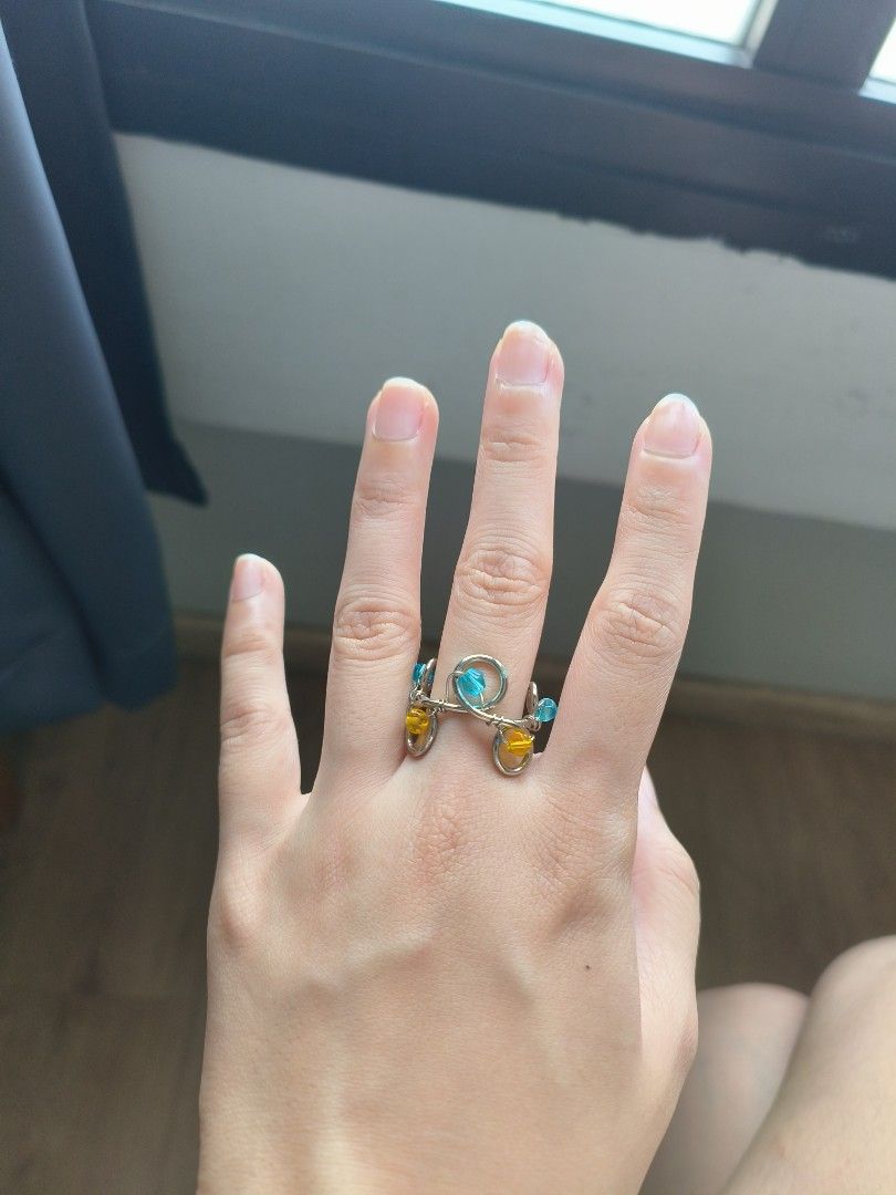 Beaded Ring (Category: Rings) located in Singapore. Submitted by foodcaptures (Listing ID 1455021833, Image 2). Description: - Handmade beaded ring - Features blue and yellow beads - Unique wire-wrapped design - Adds a pop of color to your style.