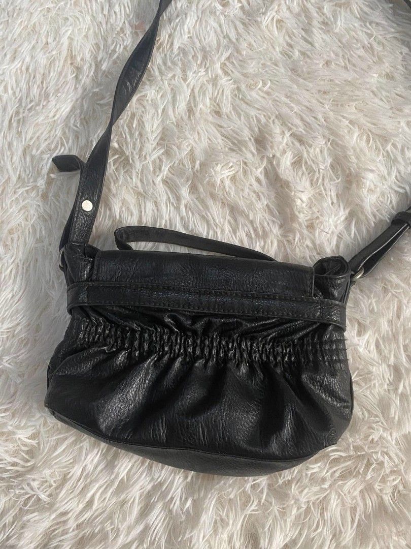 Calvin Klein Jeans Black Leather Shoulder Bag (Category: Shoulder Bags) located in Manila. Submitted by thritingera25 (Listing ID 1455136436, Image 3). Description: Black leather shoulder bag from Calvin Klein Jeans. Features a silver CK buckle closure. Ruched detailing on the front. Adjustable strap. Great for everyday use. Shows some signs of wear on the leather and strap..