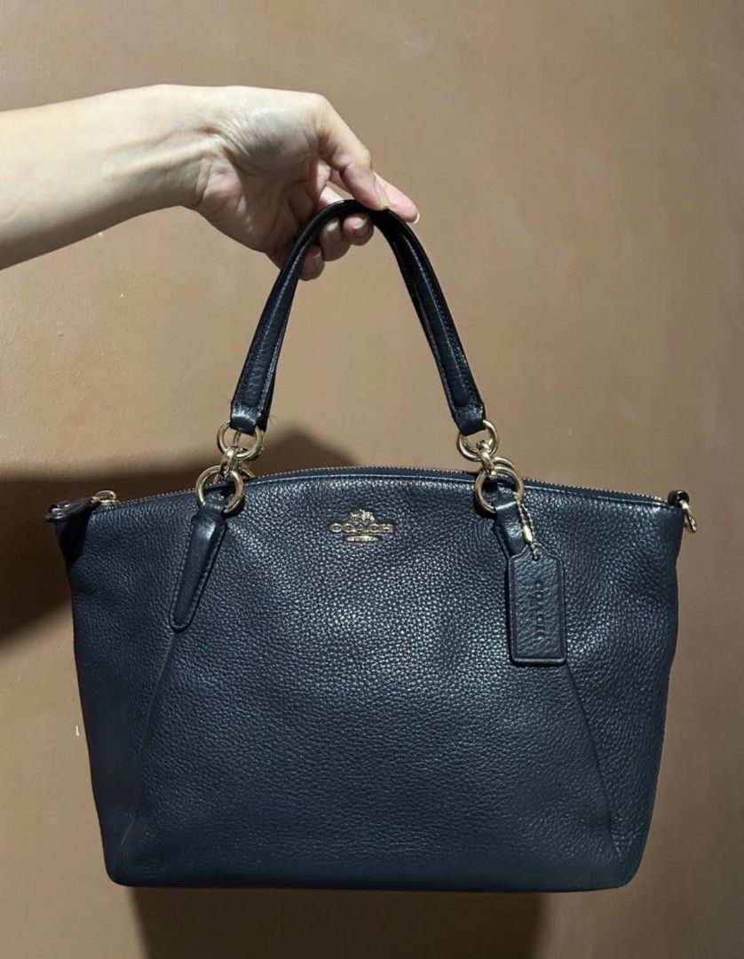 Coach Pebble Leather Satchel Handbag (Category: Luxury Bags & Wallets) located in Las Pinas. Submitted by luxeprelovedstuff (Listing ID 1455005422, Image 1). Description: -still like new - Navy blue Coach satchel - Genuine pebble leather with gold hardware - Secure top zip closure - Interior zip and slip pockets for organization - Includes a detachable crossbody strap for versatile wear - Ideal everyday bag with origibal dustbag.
