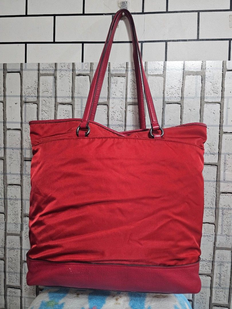 Coach Red Nylon Leather Tote Bag (Category: Luxury Bags & Wallets) located in Cavite. Submitted by liveriver_514fd1 (Listing ID 1448417143, Image 2). Description: - Red Coach tote bag - Combination of nylon and leather materials - Spacious interior with a zippered pocket for secure storage - Comfortable shoulder straps for easy carrying - Ideal for everyday use or travel - Shows some signs of wear, but still has plenty of life left.