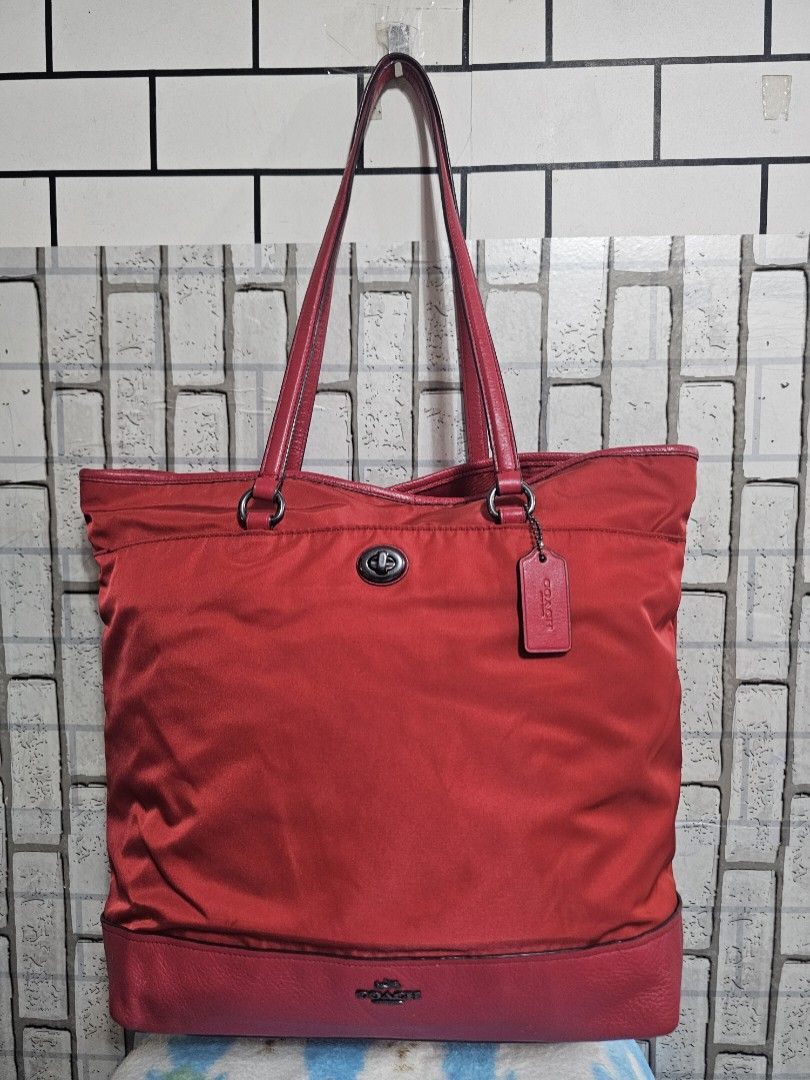 Coach Red Nylon Leather Tote Bag (Category: Luxury Bags & Wallets) located in Cavite. Submitted by liveriver_514fd1 (Listing ID 1448417143, Image 1). Description: - Red Coach tote bag - Combination of nylon and leather materials - Spacious interior with a zippered pocket for secure storage - Comfortable shoulder straps for easy carrying - Ideal for everyday use or travel - Shows some signs of wear, but still has plenty of life left.