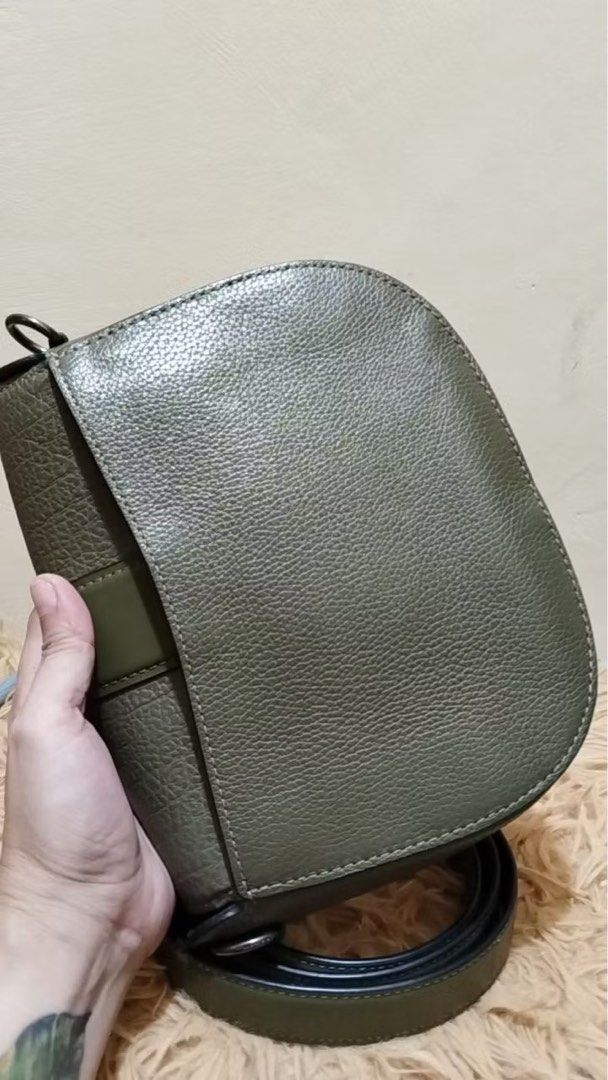 Coach Saddle Bag Olive Green Leather Suede (Category: Luxury Bags & Wallets) located in Quezon City. Submitted by _rinyang (Listing ID 1455015759, Image 3). Description: - Olive green Coach saddle bag - Textured leather with suede front flap accents - Silver horse and carriage logo hardware - Detachable crossbody strap included - Ideal size for everyday essentials - Clean interior - Ready for a new owner.