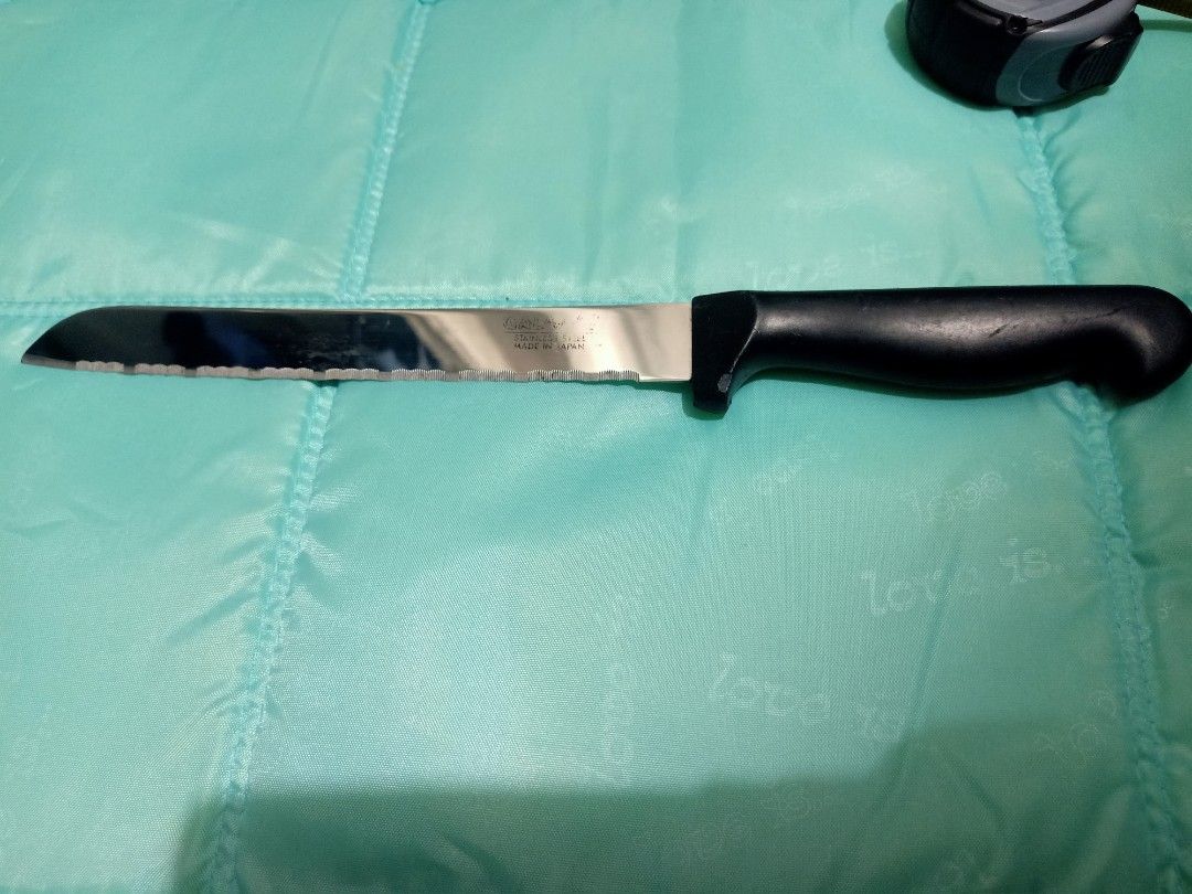 Galaxy stainless steel serrated bread knife (Category: Knives & Chopping Boards) located in Pasig City. Submitted by urdal01 (Listing ID 1455110016, Image 2). Description: - Galaxy stainless steel serrated bread knife with a black plastic handle, featuring a wavy edge and stamped text on the blade indicating it is made of stainless steel. -made in japan -Blade Type: Long, serrated/wavy edge designed for slicing through crusty bread or soft cakes 