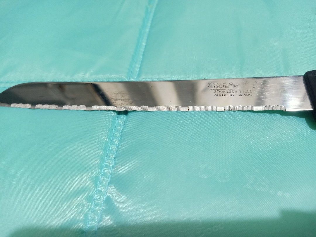 Galaxy stainless steel serrated bread knife (Category: Knives & Chopping Boards) located in Pasig City. Submitted by urdal01 (Listing ID 1455110016, Image 3). Description: - Galaxy stainless steel serrated bread knife with a black plastic handle, featuring a wavy edge and stamped text on the blade indicating it is made of stainless steel. -made in japan -Blade Type: Long, serrated/wavy edge designed for slicing through crusty bread or soft cakes 