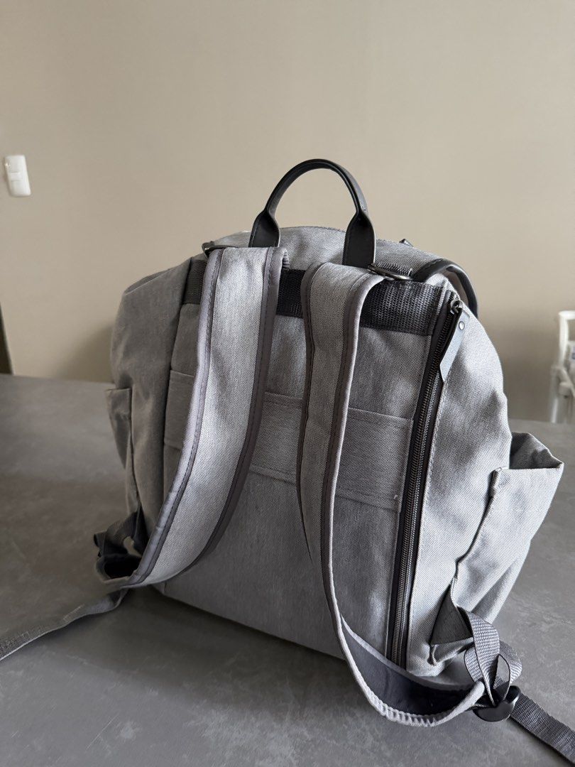 Grey Diaper Backpack with Changing Mat, Bottle Holder & Pouch (Category: Diaper Bags & Wetbags) located in Taytay. Submitted by thestyletwins (Listing ID 1455065991, Image 3). Description: - Grey diaper backpack set - Includes changing mat, bottle holder, and small pouch - Multiple pockets for excellent organization - Zippers in good working condition - Adjustable straps for comfort - Perfect for parents on the go.