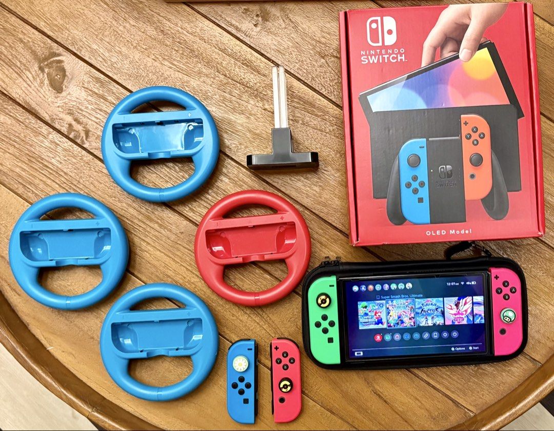 Nintendo Switch OLED Version (Category: Nintendo) located in Singapore. Submitted by azeis (Listing ID 1454985245, Image 1). Description: Bought near end 2024. Mint Condition. Selling full set with box. Comes with 2 additional original Joycon controllers. Comes with additional accessories as pictured: 1. 4 x Steering Attachment for Joycon Controllers. 2. Charging Port for 4 x Joycons .