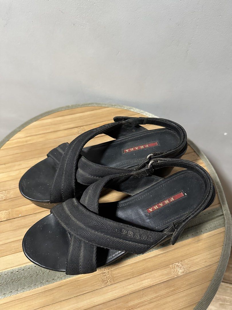 Prada Black Wedge Sandals (Category: Sneakers & Footwear) located in Quezon City. Submitted by phinksummercollectionbackup (Listing ID 1455088613, Image 2). Description: - Authentic Black Prada Wedge Sandals - Comfortable fabric criss-cross straps over the foot - Secure slingback strap with adjustable buckle closure - Stylish platform wedge heel - Classic Prada logo detail on the insole - Perfect for elevating both casual and formal looks.