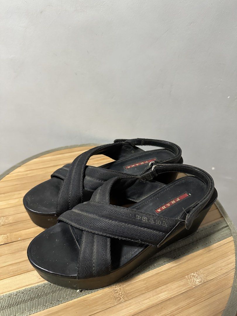 Prada Black Wedge Sandals (Category: Sneakers & Footwear) located in Quezon City. Submitted by phinksummercollectionbackup (Listing ID 1455088613, Image 1). Description: - Authentic Black Prada Wedge Sandals - Comfortable fabric criss-cross straps over the foot - Secure slingback strap with adjustable buckle closure - Stylish platform wedge heel - Classic Prada logo detail on the insole - Perfect for elevating both casual and formal looks.