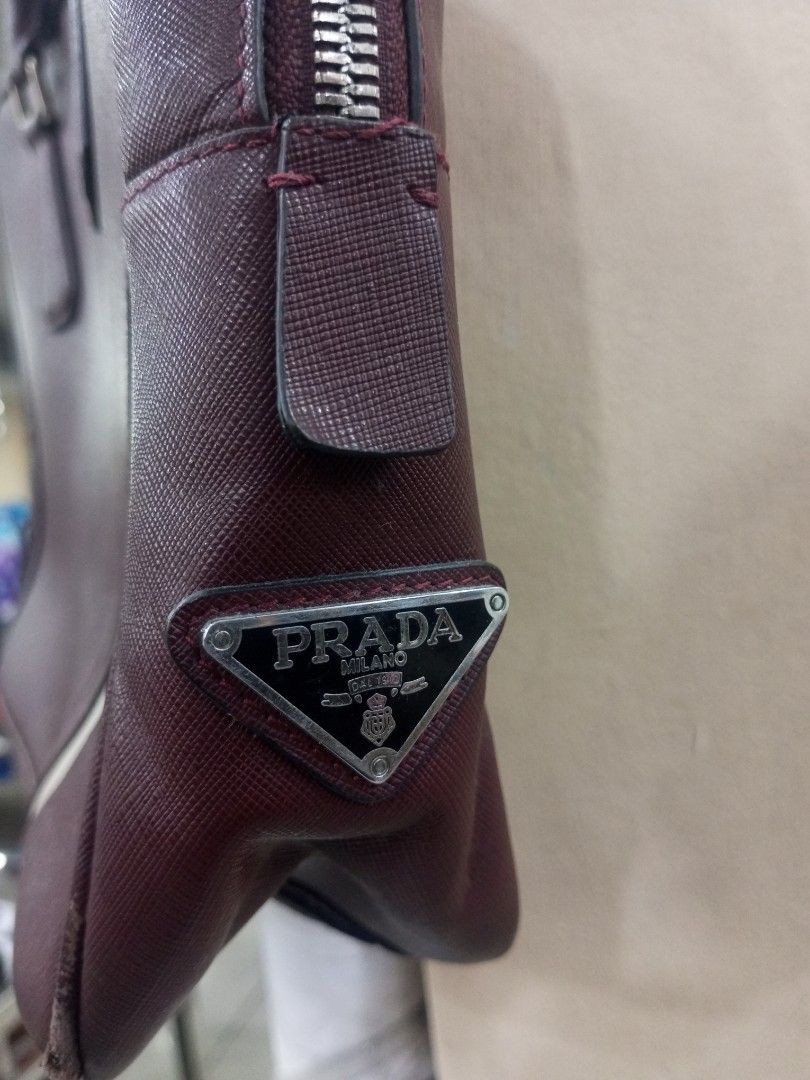 Prada Burgundy Leather Briefcase Bag with White Stripes (Category: Luxury Bags & Wallets) located in Bacolod City. Submitted by exequelgra46775 (Listing ID 1455081365, Image 3). Description: - Authentic Prada burgundy leather Documents Briefcase bag - Features two distinctive white stripes on the front - Secure zipper closure - Interior includes original Prada Made in Italy tag - Durable metal hardware on the zipper - Sturdy and comfortable handl