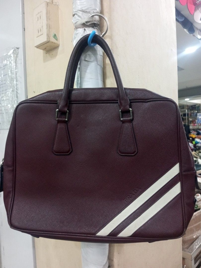 Prada Burgundy Leather Briefcase Bag with White Stripes (Category: Luxury Bags & Wallets) located in Bacolod City. Submitted by exequelgra46775 (Listing ID 1455081365, Image 1). Description: - Authentic Prada burgundy leather Documents Briefcase bag - Features two distinctive white stripes on the front - Secure zipper closure - Interior includes original Prada Made in Italy tag - Durable metal hardware on the zipper - Sturdy and comfortable handl