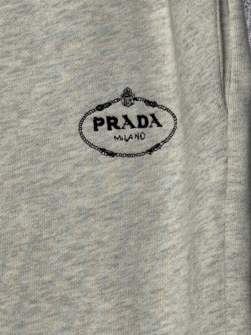 Prada Grey Sweatpants with Striped Cuffs (Category: Joggers) located in Manila. Submitted by dipdrip (Listing ID 1455081610, Image 3). Description: - Prada grey sweatpants - Comfortable and stylish design - Elastic waistband with adjustable drawstring - Ribbed cuffs featuring classic navy and white stripes - Subtle Prada logo detail on the left thigh - Ideal for lounging at home or casual everyday wear DIMENSIONS Waist : 28 can stretch to 34 Leng