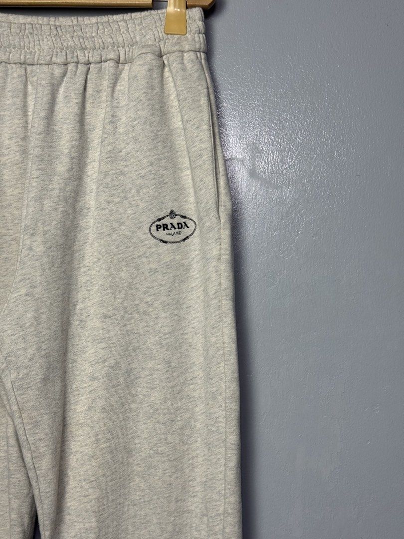 Prada Grey Sweatpants with Striped Cuffs (Category: Joggers) located in Manila. Submitted by dipdrip (Listing ID 1455081610, Image 2). Description: - Prada grey sweatpants - Comfortable and stylish design - Elastic waistband with adjustable drawstring - Ribbed cuffs featuring classic navy and white stripes - Subtle Prada logo detail on the left thigh - Ideal for lounging at home or casual everyday wear DIMENSIONS Waist : 28 can stretch to 34 Leng