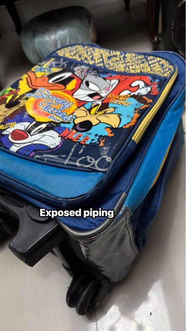 Preloved Looney Tunes Stroller Bag with Wheels (Category: Strollers) located in Cainta. Submitted by elainelawenko (Listing ID 1455035193, Image 3). Description: - Blue stroller bag featuring fun Looney Tunes characters - Equipped with wheels and a retractable handle for easy transport - Spacious interior, perfect for travel or school essentials - Please note: Minor flaws include a small hole and some exposed piping.