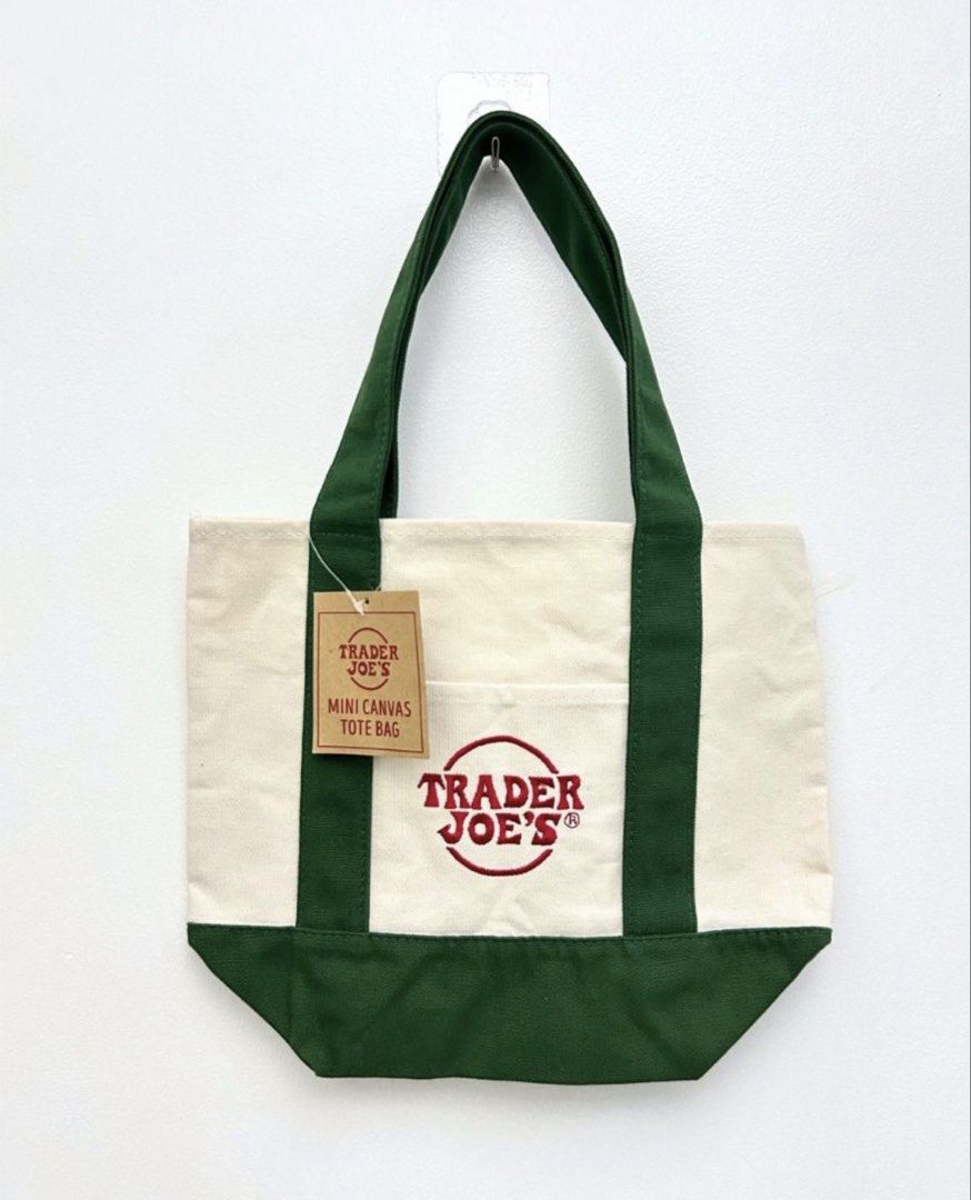 Trader Joe's Mini Canvas Tote Bag (Green) (Category: Tote Bags) located in Quezon City. Submitted by rjsjsgs (Listing ID 1455012037, Image 1). Description: - Trader Joe’s Mini Canvas Tote Bag (with original tag) - features a front pocket with embroidered Trader Joe’s logo - ideal for quick errands and carrying essentials - COLOR: cream with green trim and handles.
