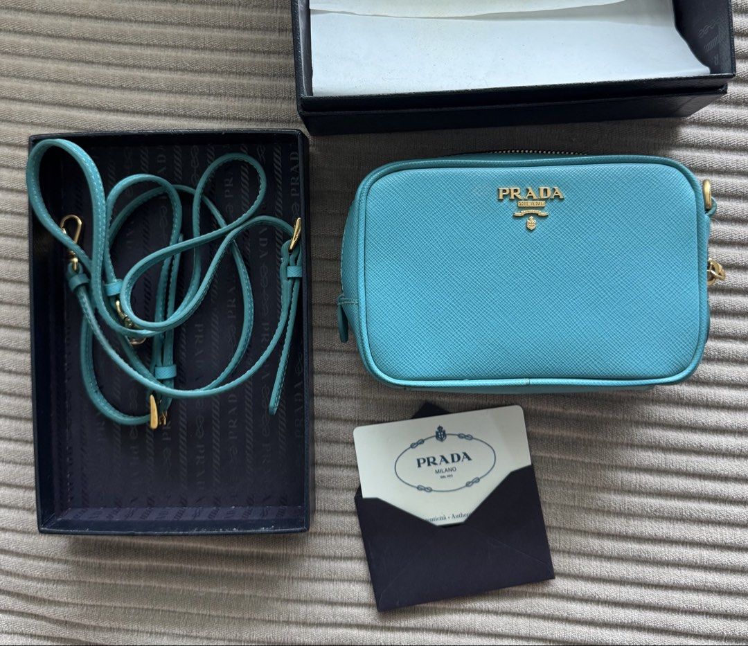 turquoise Prada Saffiano Leather Mini Camera Bag (Category: Luxury Bags & Wallets) located in Pasig City. Submitted by jesych (Listing ID 1454998057, Image 1). Description: - Authentic Prada Saffiano Leather Mini Camera Bag - Stunning turquoise color - Durable Saffiano leather material - Versatile crossbody style - Comes with original box and authenticity card - Perfect for adding a touch of luxury to your everyday look.