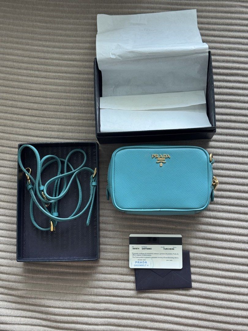 turquoise Prada Saffiano Leather Mini Camera Bag (Category: Luxury Bags & Wallets) located in Pasig City. Submitted by jesych (Listing ID 1454998057, Image 2). Description: - Authentic Prada Saffiano Leather Mini Camera Bag - Stunning turquoise color - Durable Saffiano leather material - Versatile crossbody style - Comes with original box and authenticity card - Perfect for adding a touch of luxury to your everyday look.
