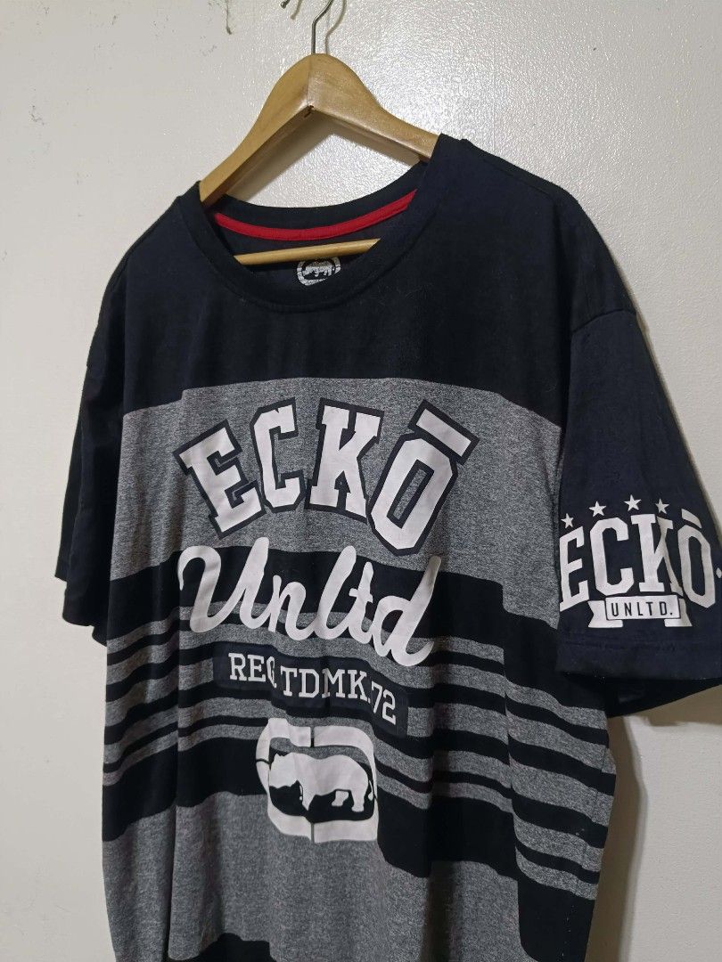 Y2k Ecko Unltd. Graphic T-Shirt 3XL (Category: Tshirts & Polo Shirts ) located in Caloocan City. Submitted by Tulokss (Listing ID 1455119444, Image 1). Description: - Brand: Ecko Unltd. - Size: 3XL - Color: Black and grey stripes - Design: Features Ecko logo and text graphics on front and sleeve - Material: Made in China - Occasion: Great for casual wear issue : lints.
