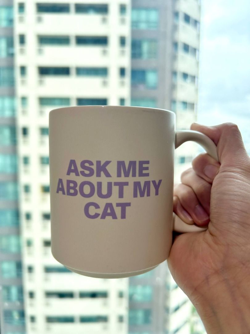 "Ask Me About My Cat” Ceramic Mug (Category: Coffee & Tea Tableware) located in Manila. Submitted by softlysorted (Listing ID 1455195268, Image 2). Description: Cute ceramic mug from Typo featuring the phrase “Ask Me About My Cat” in purple print. Perfect for cat lovers, as a desk mug, or as a fun gift. • Authentic Typo item; designed in Australia • Neutral cream color with purple lettering • Dishwasher safe • Microwave safe • Care guide booklet 