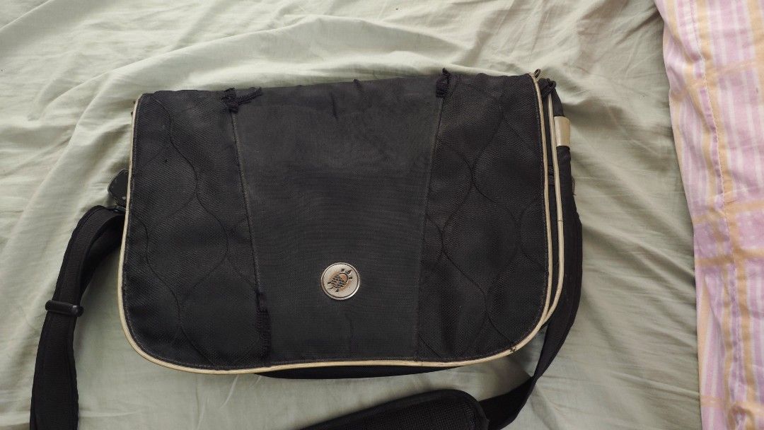 Black Messenger Bag with Tan Trim (Category: Luxury Bags & Wallets) located in Tarlac. Submitted by limidoloy191416 (Listing ID 1455206979, Image 1). Description: - Stylish black messenger bag with classic tan trim. - Spacious main compartment for your essentials. - Convenient front pockets for quick access. - Visible wear and tear on the top flap, as detailed in the close-up photo. - Adjustable shoulder strap for a comfortable fit. - Perfect for