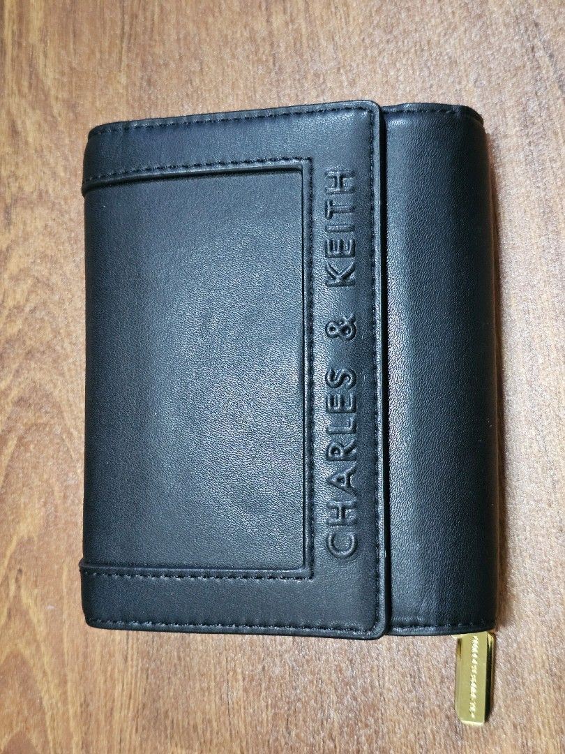 Charles & Keith Black Leather Tri-fold Wallet (Category: Wallets & Card holders) located in Paranaque City. Submitted by rhodalietagle (Listing ID 1455170900, Image 1). Description: - Brand: Charles & Keith - Color: Black - Style: Tri-fold wallet - Material: Leather - Features: Multiple card slots, zipper coin compartment - Hardware: Gold details - Size: Compact, fits pockets/small bags - Condition: Clean interior - Bought 2023 .