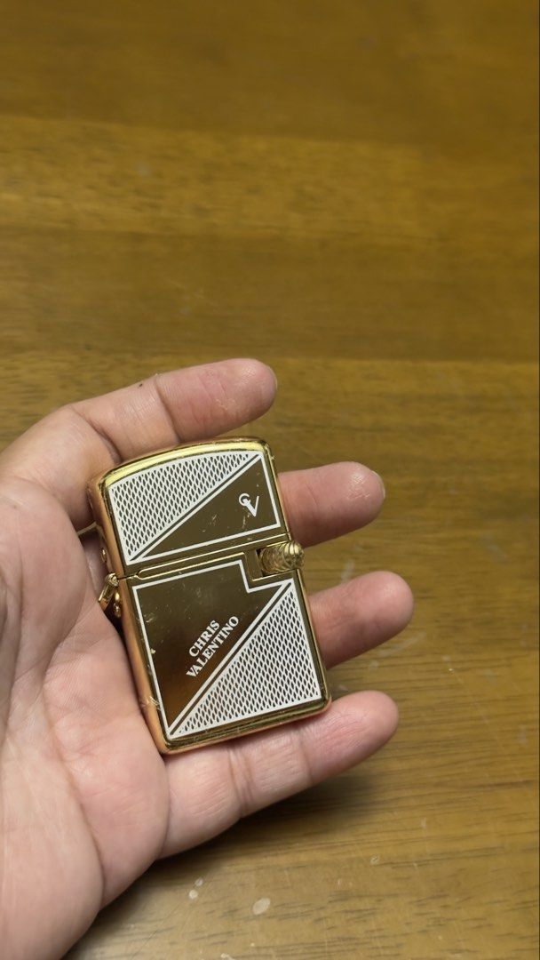 Chris Valentino Gold Lighter (Category: Fragrance & Deodorants) located in Pilar. Submitted by faveanyshop (Listing ID 1455248759, Image 1). Description: - Classic gold flip lighter - Engraved with 'CHRIS VALENTINO' - Features a patterned design - Ideal for collectors or everyday use.