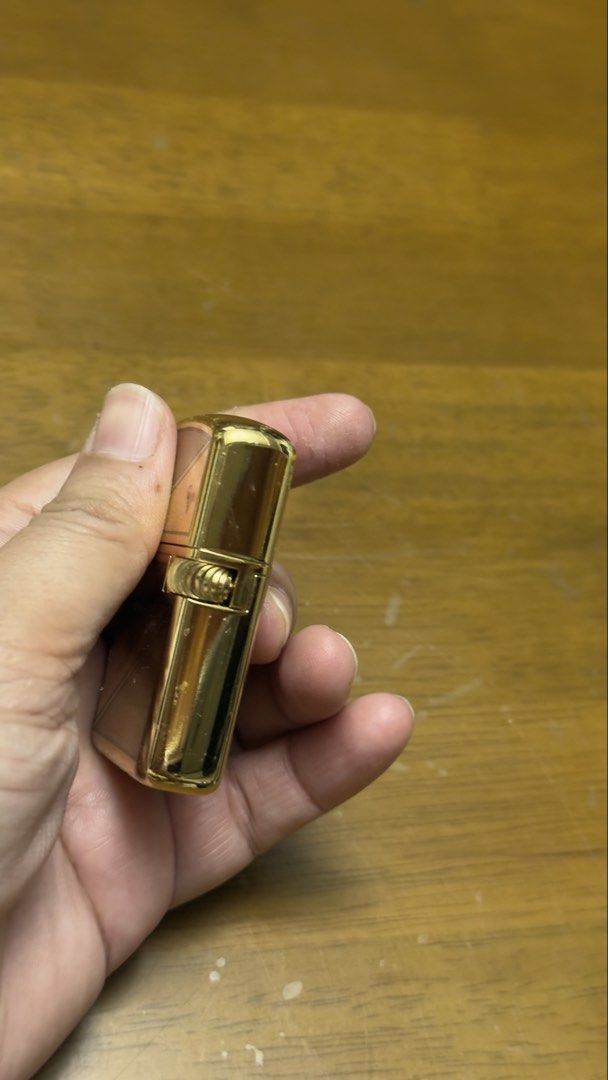 Chris Valentino Gold Lighter (Category: Fragrance & Deodorants) located in Pilar. Submitted by faveanyshop (Listing ID 1455248759, Image 2). Description: - Classic gold flip lighter - Engraved with 'CHRIS VALENTINO' - Features a patterned design - Ideal for collectors or everyday use.