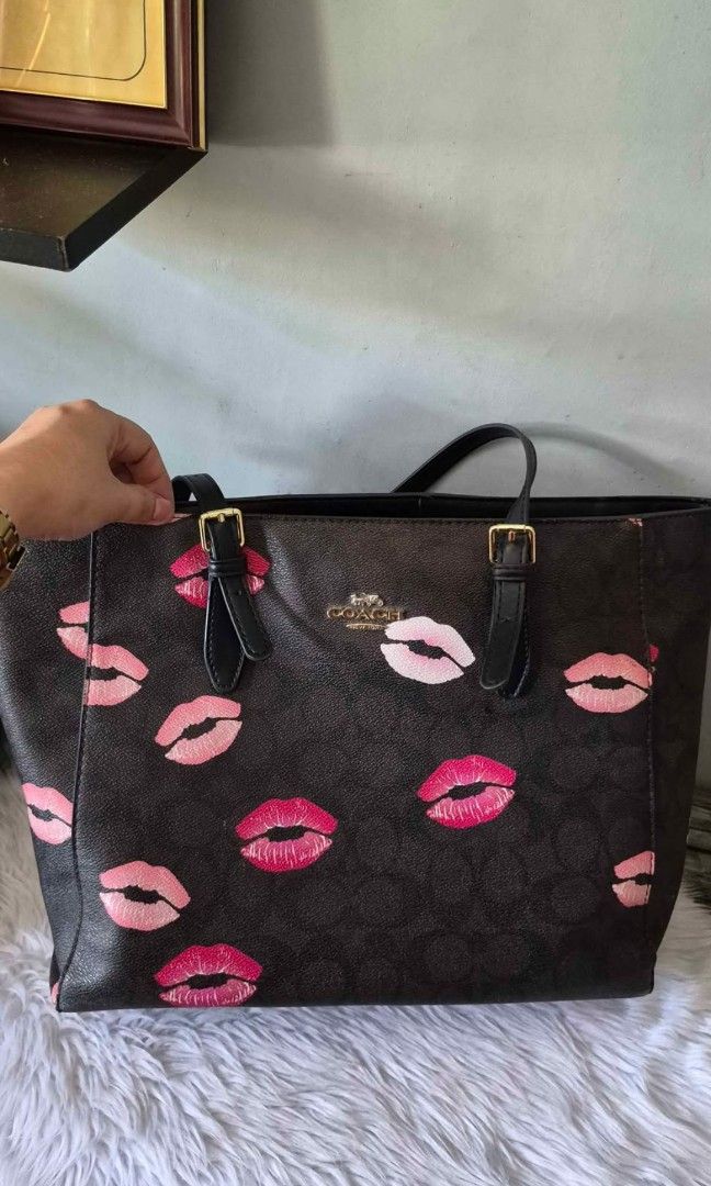 Coach Black and Pink Lips Tote Bag (Category: Luxury Bags & Wallets) located in Quezon City. Submitted by shynp (Listing ID 1455268437, Image 1). Description: 💋 Black & Pink Lips Tote Bag 🖤💗 Fun, stylish, and definitely a statement piece! Perfect if you love a cute Y2K-inspired look. ✨ • Spacious tote design • Black body with pink lip print • Structured shape • Adjustable handles • Perfect for everyday use 📩 DM to order/inquire 📦 Shipping av