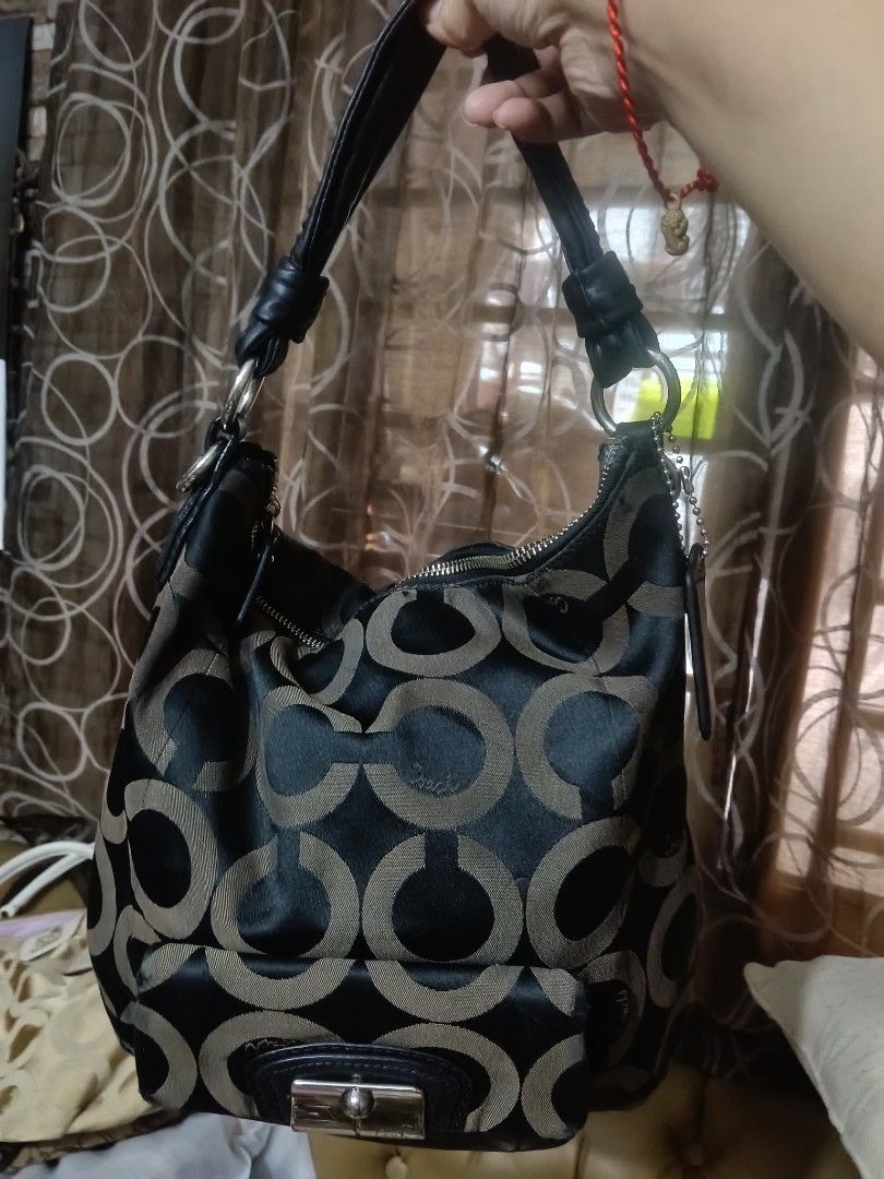 Coach Signature Pattern Hobo Bag (Category: Luxury Bags & Wallets) located in Quezon City. Submitted by bshoppe_ (Listing ID 1455174498, Image 1). Description: - Coach hobo bag - Classic signature 'C' pattern - Black and tan colorway - Zipper closure on top - Interior zip pocket and slip pockets - Silver hardware - Leather straps and trim - Stylish everyday bag - no issue.only small dot mark inside.