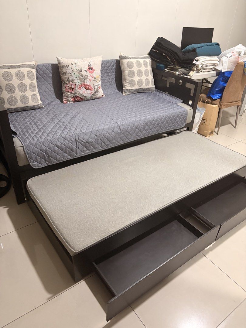 Dark Wood Sofa Bed with Pull-out Trundle and Storage (Category: Sofas) located in Manila. Submitted by miguelfits (Listing ID 1455239505, Image 2). Description: - Dark wood sofa bed with grey quilted fabric - Pull-out trundle for guests - Two built-in storage drawers in trundle frame - Includes 3 decorative pillows - Ideal for small spaces.