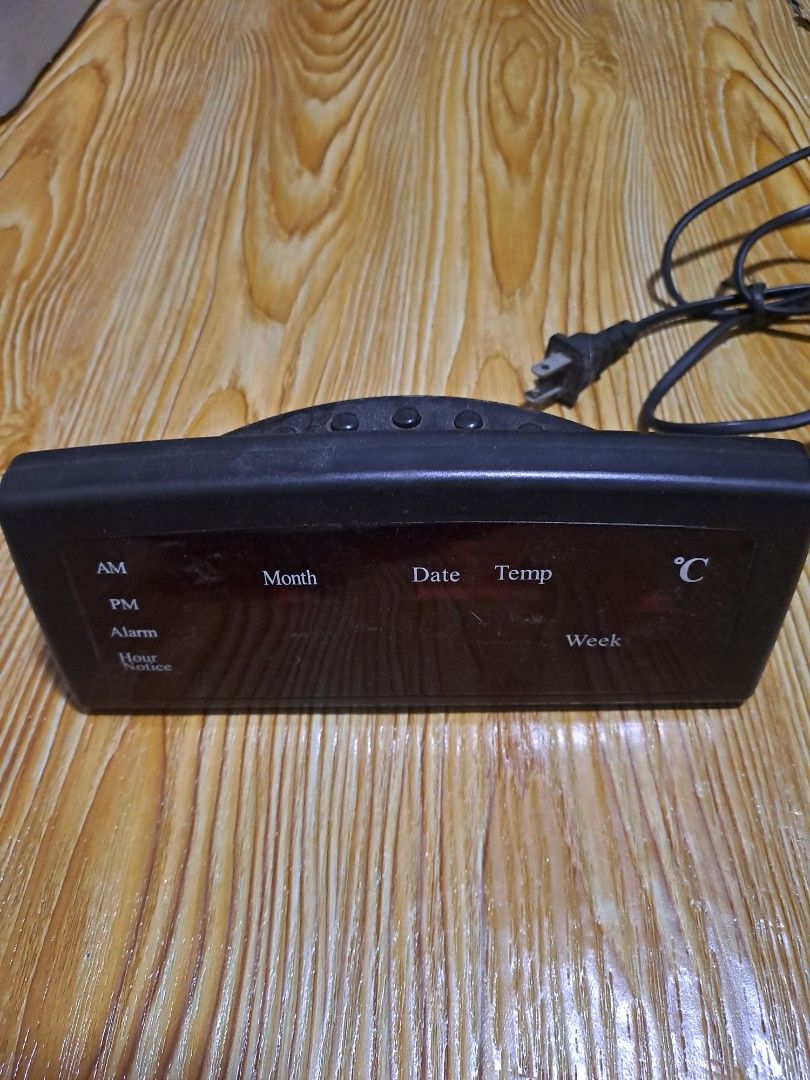Digital Alarm Clock with Temperature and Date Display (Category: Clocks) located in Las Pinas. Submitted by cobieshop (Listing ID 1455255228, Image 2). Description: - Sleek black digital alarm clock - Bright red LED display for clear visibility - Shows time, month, date, temperature, and day of the week - Easy-to-use side buttons for settings - Comes complete with a power cord - Fully functional and works well.