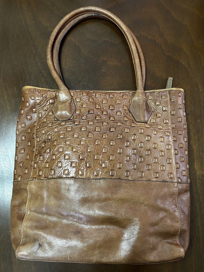 DUMOND Brown Leather Studded Tote Bag (Category: Tote Bags) located in Manila. Submitted by my_krophone (Listing ID 1455211170, Image 2). Description: - Brand: DUMOND - Material: Genuine Leather - Color: Brown - Design: Classic tote shape - Front Panel: Textured with studs - Lower Section: Smooth leather - Interior: DUMOND logo printed lining - Handles: Leather - Ideal for: Everyday use.