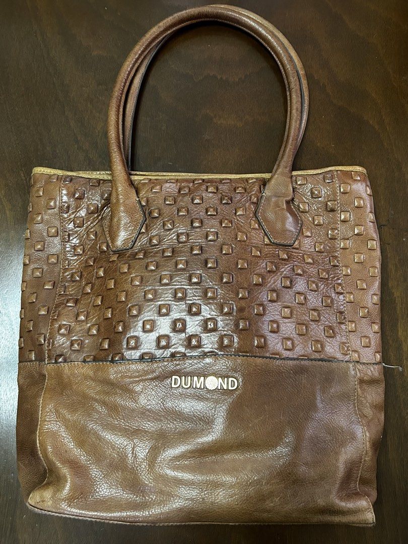 DUMOND Brown Leather Studded Tote Bag (Category: Tote Bags) located in Manila. Submitted by my_krophone (Listing ID 1455211170, Image 1). Description: - Brand: DUMOND - Material: Genuine Leather - Color: Brown - Design: Classic tote shape - Front Panel: Textured with studs - Lower Section: Smooth leather - Interior: DUMOND logo printed lining - Handles: Leather - Ideal for: Everyday use.